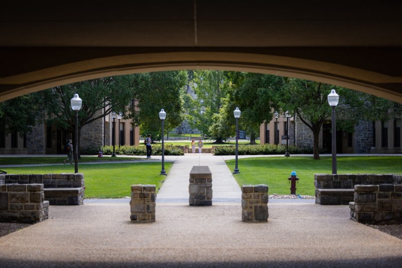 Four students walk outside the residence halls.